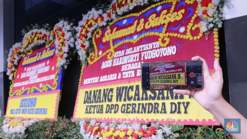 Pekerja menaruh karangan bunga bertuliskan ucapan selamat atas pelantikan AHY sebagai Menteri ATR/Kepala BPN di kantor Kementerian ATR/BPN, Jakarta, Rabu (21/2/2024). (վ/Muhammad Sabki)