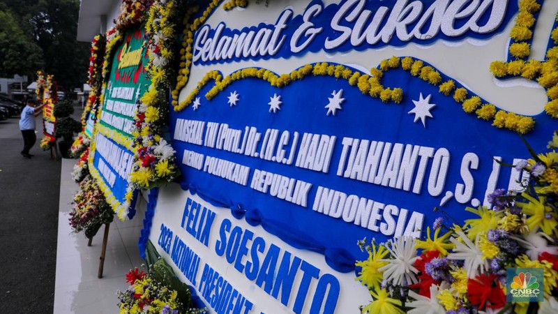 Pekerja menaruh karangan bunga bertuliskan ucapan selamat dan sukses atas pelantikan Marsekal (Purn) TNI Hadi Tjahjanto di kantor Kementrian Koordinator Bidang Politik, Hukum, dan Keamanan RI (Kemenko Polhukam), Jakarta, Rabu (21/2/2024). (CNBC Indonesia/Faisal Rahman)