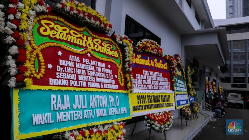 Pekerja menaruh karangan bunga bertuliskan ucapan selamat dan sukses atas pelantikan Marsekal (Purn) TNI Hadi Tjahjanto di kantor Kementrian Koordinator Bidang Politik, Hukum, dan Keamanan RI (Kemenko Polhukam), Jakarta, Rabu (21/2/2024). (CNBC Indonesia/Faisal Rahman)