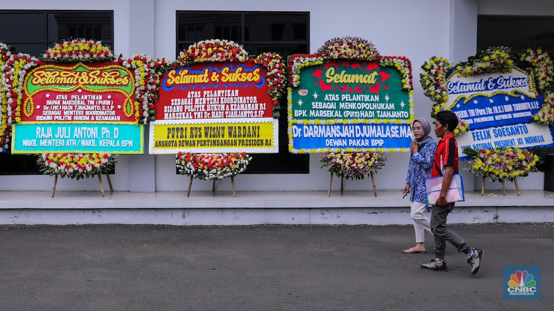 Pekerja menaruh karangan bunga bertuliskan ucapan selamat dan sukses atas pelantikan Marsekal (Purn) TNI Hadi Tjahjanto di kantor Kementrian Koordinator Bidang Politik, Hukum, dan Keamanan RI (Kemenko Polhukam), Jakarta, Rabu (21/2/2024). (CNBC Indonesia/Faisal Rahman)