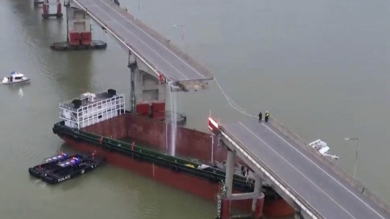 Dalam gambar dari video yang dirilis CCTV Tiongkok ini, orang-orang memeriksa Jembatan Lixinsha yang rusak setelah ditabrak kapal kontainer di Distrik Nansha, Guangzhou, Provinsi Guangdong, China selatan, Kamis, 22 Februari 2024. Dalam gambar dari video yang dirilis CCTV Tiongkok ini, orang-orang memeriksa Jembatan Lixinsha yang rusak setelah ditabrak kapal kontainer di Distrik Nansha, Guangzhou, Provinsi Guangdong, China selatan, Kamis, 22 Februari 2024. Hanya sedikit orang yang tewas dan hilang setelah kecelakaan. kapal kontainer besar menabrak jembatan di selatan kota Guangzhou di China selatan pada Kamis pagi, menyebabkan sebagian jembatan runtuh bersama dengan kendaraan. (CCTV via AP Video)