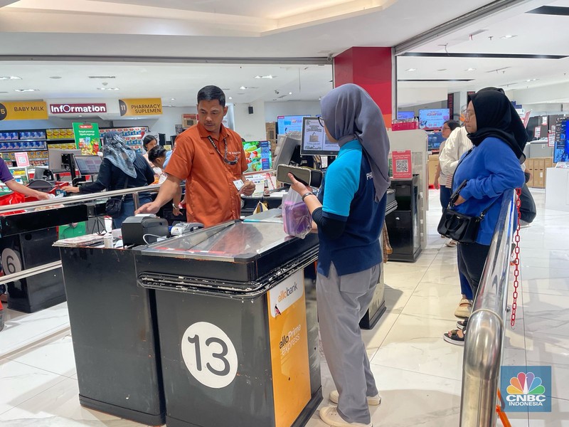 Seorang pengunjung Transmart Transpark Mall Bintaro Bintaro memborong sejumlah produk selama promo Transmart Full Day Sale pada Sabtu, (24/2/2024). (CNBC Indonesia/Rindi Salsabilla)