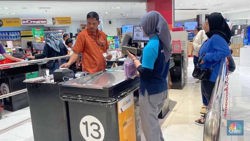 Seorang pengunjung Transmart Transpark Mall Bintaro Bintaro memborong sejumlah produk selama promo Transmart Full Day Sale pada Sabtu, (24/2/2024). (CNBC Indonesia/Rindi Salsabilla)
