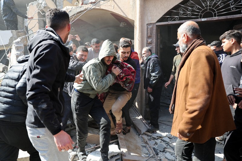 ISRAEL-PALESTINIANS/ Palestinians inspect the site of an Israeli strike on a house, amid the ongoing conflict between Israel and Hamas, in Rafah, in the southern Gaza Strip February 24, 2024. REUTERS/Ibraheem Abu Mustafa