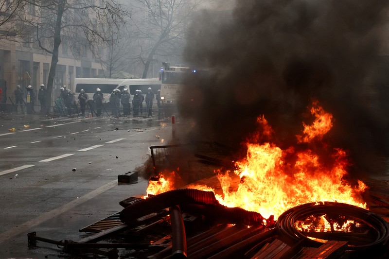 Asap mengepul ketika orang-orang mengambil bagian dalam protes petani Eropa atas tekanan harga, pajak, dan peraturan ramah lingkungan, pada hari pertemuan Menteri Pertanian Uni Eropa di Brussels, Belgia, 26 Februari 2024. (REUTERS/Yves Herman)