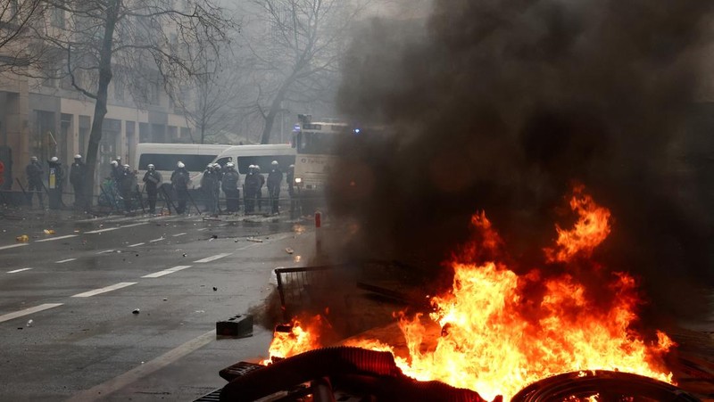 Asap mengepul ketika orang-orang mengambil bagian dalam protes petani Eropa atas tekanan harga, pajak, dan peraturan ramah lingkungan, pada hari pertemuan Menteri Pertanian Uni Eropa di Brussels, Belgia, 26 Februari 2024. (REUTERS/Yves Herman)
