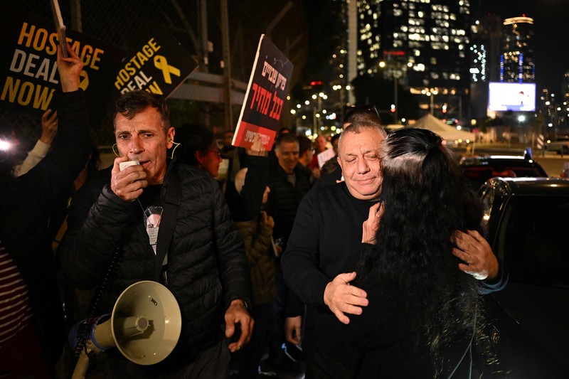 Demonstran memblokir jalan saat melakukan aksi unjuk rasa di Tel Aviv, Israel, Minggu (25/2/2024) malam. (REUTERS/Dylan Martinez)