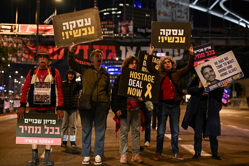 Demonstran memblokir jalan saat melakukan aksi unjuk rasa di Tel Aviv, Israel, Minggu (25/2/2024) malam. (REUTERS/Dylan Martinez)