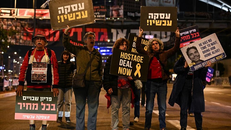 Demonstran memblokir jalan saat melakukan aksi unjuk rasa di Tel Aviv, Israel, Minggu (25/2/2024) malam. (REUTERS/Dylan Martinez)
