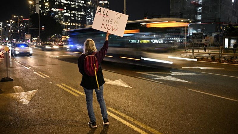 Demonstran memblokir jalan saat melakukan aksi unjuk rasa di Tel Aviv, Israel, Minggu (25/2/2024) malam. (REUTERS/Dylan Martinez)