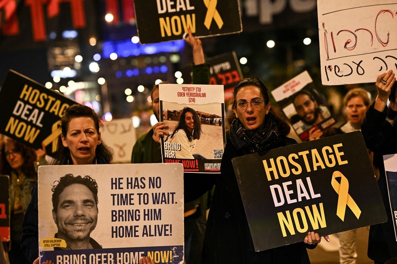 Demonstran memblokir jalan saat melakukan aksi unjuk rasa di Tel Aviv, Israel, Minggu (25/2/2024) malam. (REUTERS/Dylan Martinez)