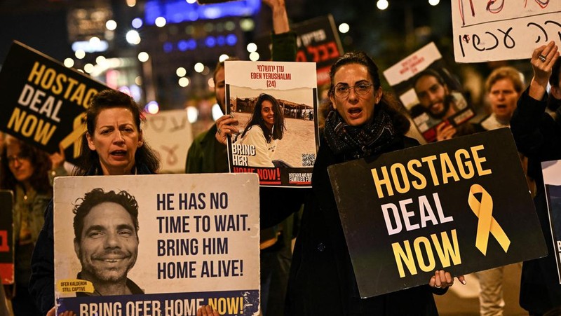 Demonstran memblokir jalan saat melakukan aksi unjuk rasa di Tel Aviv, Israel, Minggu (25/2/2024) malam. (REUTERS/Dylan Martinez)