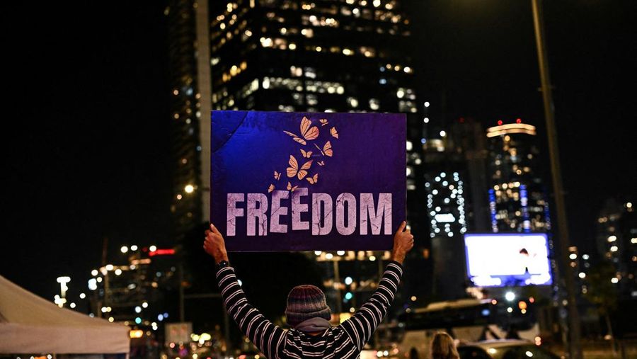 Demonstran memblokir jalan saat melakukan aksi unjuk rasa di Tel Aviv, Israel, Minggu (25/2/2024) malam. (REUTERS/Dylan Martinez)