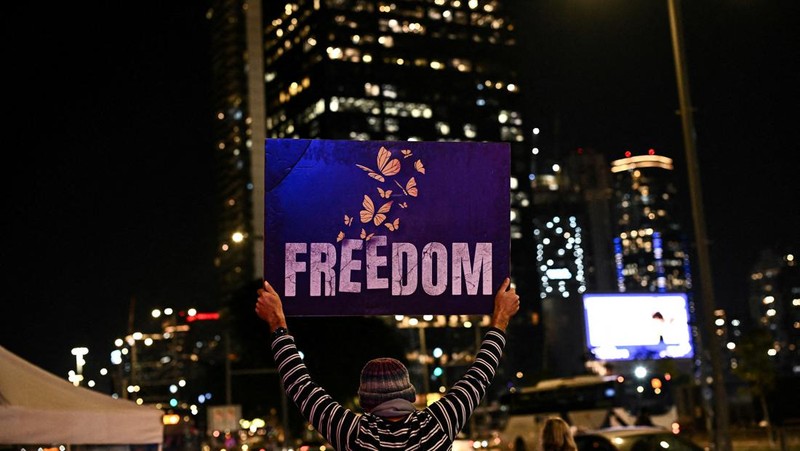 Demonstran memblokir jalan saat melakukan aksi unjuk rasa di Tel Aviv, Israel, Minggu (25/2/2024) malam. (REUTERS/Dylan Martinez)