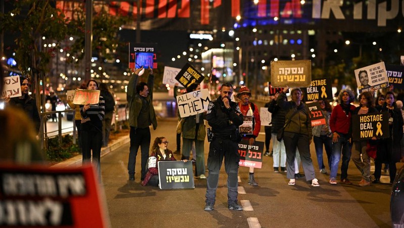 Demonstran memblokir jalan saat melakukan aksi unjuk rasa di Tel Aviv, Israel, Minggu (25/2/2024) malam. (REUTERS/Dylan Martinez)
