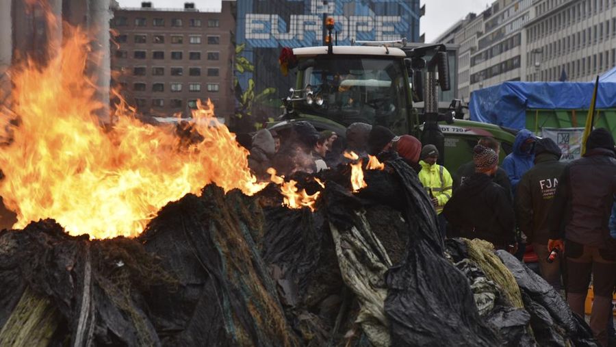 Asap mengepul ketika orang-orang mengambil bagian dalam protes petani Eropa atas tekanan harga, pajak, dan peraturan ramah lingkungan, pada hari pertemuan Menteri Pertanian Uni Eropa di Brussels, Belgia, 26 Februari 2024. (REUTERS/Yves Herman)