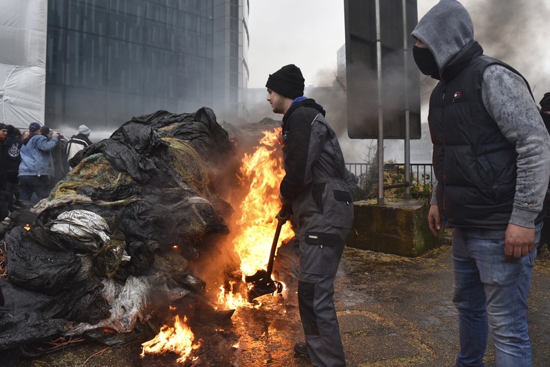 Asap mengepul ketika orang-orang mengambil bagian dalam protes petani Eropa atas tekanan harga, pajak, dan peraturan ramah lingkungan, pada hari pertemuan Menteri Pertanian Uni Eropa di Brussels, Belgia, 26 Februari 2024. Asap mengepul ketika orang-orang mengambil bagian dalam protes petani Eropa atas tekanan harga, pajak, dan peraturan ramah lingkungan, pada hari pertemuan Menteri Pertanian Uni Eropa di Brussels, Belgia, 26 Februari 2024. (REUTERS/Yves Herman)