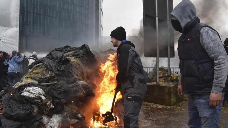 Asap mengepul ketika orang-orang mengambil bagian dalam protes petani Eropa atas tekanan harga, pajak, dan peraturan ramah lingkungan, pada hari pertemuan Menteri Pertanian Uni Eropa di Brussels, Belgia, 26 Februari 2024. (REUTERS/Yves Herman)
