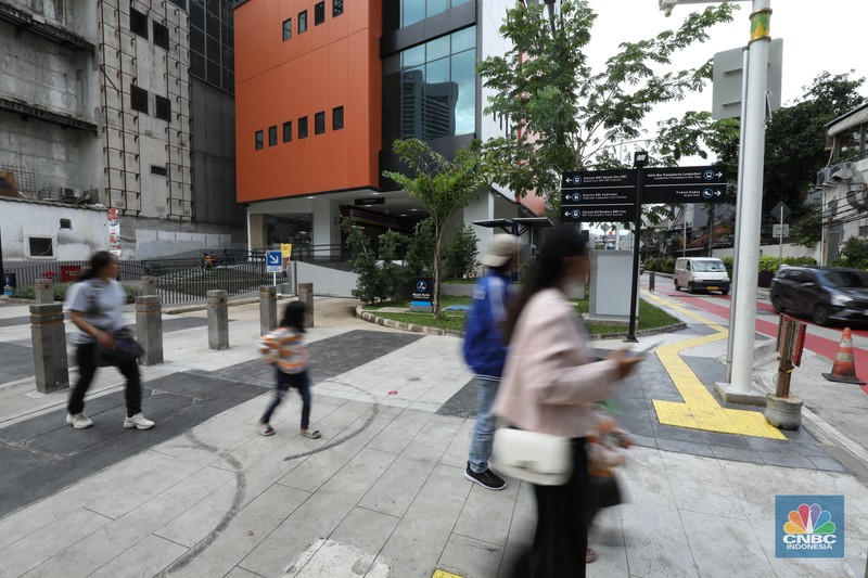 Warga berjalan melewati kawasan Transport Hub Dukuh Atas, Jakarta, Senin (26/2/2024). (CNBC Indonesia/Tri Susilo)