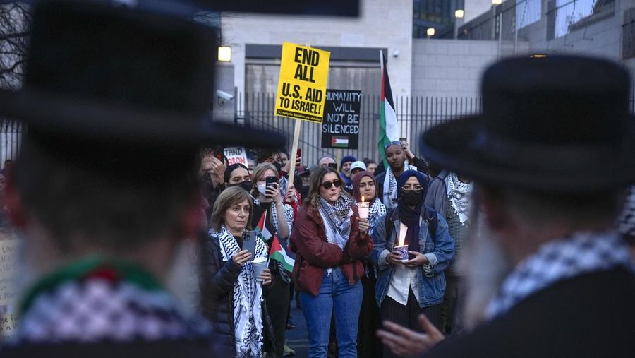 Demonstran menyalakan lilin saat berjaga di luar Kedutaan Besar Israel, Senin, 26 Februari 2024, di Washington. Seorang anggota aktif Angkatan Udara AS meninggal setelah dia membakar dirinya sendiri di luar Kedutaan Besar Israel di Washington, sambil menyatakan bahwa dia 