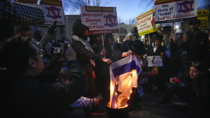 Demonstran menyalakan lilin saat berjaga di luar Kedutaan Besar Israel, Senin, 26 Februari 2024, di Washington. Seorang anggota aktif Angkatan Udara AS meninggal setelah dia membakar dirinya sendiri di luar Kedutaan Besar Israel di Washington, sambil menyatakan bahwa dia 