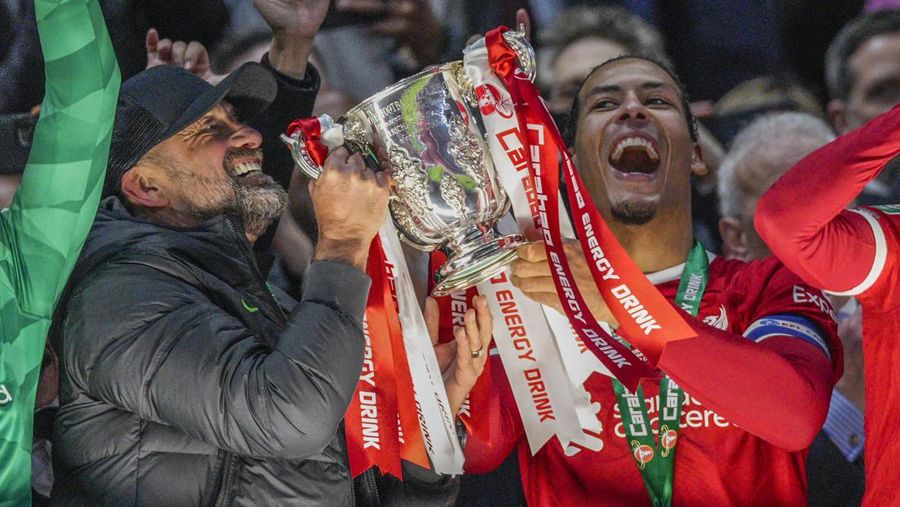 Para pemain Liverpool berpose dengan trofi setelah pertandingan sepak bola final Piala Liga Inggris antara Chelsea dan Liverpool di stadion Wembley, London, pada 25 Februari 2024. Virgil van Dijk mencetak satu-satunya gol di perpanjangan waktu saat Liverpool memenangkan Piala Liga untuk rekor kesepuluh kalinya. (Photo by Glyn KIRK / AFP)