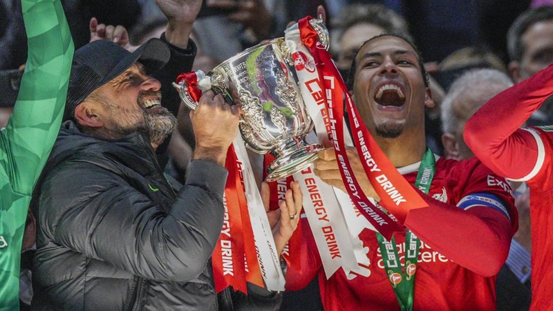 Para pemain Liverpool berpose dengan trofi setelah pertandingan sepak bola final Piala Liga Inggris antara Chelsea dan Liverpool di stadion Wembley, London, pada 25 Februari 2024. Virgil van Dijk mencetak satu-satunya gol di perpanjangan waktu saat Liverpool memenangkan Piala Liga untuk rekor kesepuluh kalinya. (Photo by Glyn KIRK / AFP)