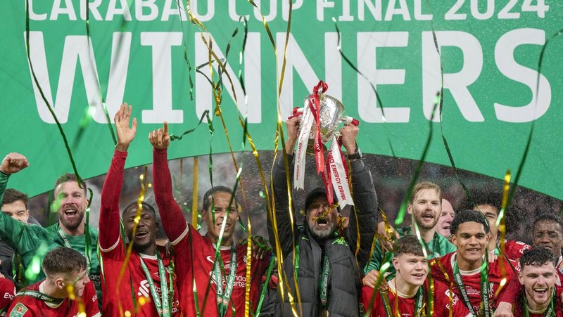 Para pemain Liverpool berpose dengan trofi setelah pertandingan sepak bola final Piala Liga Inggris antara Chelsea dan Liverpool di stadion Wembley, London, pada 25 Februari 2024. Virgil van Dijk mencetak satu-satunya gol di perpanjangan waktu saat Liverpool memenangkan Piala Liga untuk rekor kesepuluh kalinya. (Photo by Glyn KIRK / AFP)