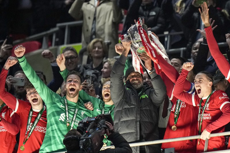 Para pemain Liverpool berpose dengan trofi setelah pertandingan sepak bola final Piala Liga Inggris antara Chelsea dan Liverpool di stadion Wembley, London, pada 25 Februari 2024. Virgil van Dijk mencetak satu-satunya gol di perpanjangan waktu saat Liverpool memenangkan Piala Liga untuk rekor kesepuluh kalinya. (Photo by Glyn KIRK / AFP)