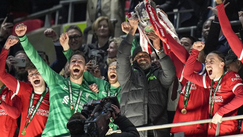 Para pemain Liverpool berpose dengan trofi setelah pertandingan sepak bola final Piala Liga Inggris antara Chelsea dan Liverpool di stadion Wembley, London, pada 25 Februari 2024. Virgil van Dijk mencetak satu-satunya gol di perpanjangan waktu saat Liverpool memenangkan Piala Liga untuk rekor kesepuluh kalinya. (Photo by Glyn KIRK / AFP)