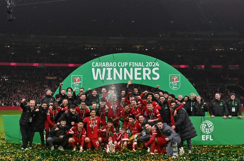 Para pemain Liverpool berpose dengan trofi setelah pertandingan sepak bola final Piala Liga Inggris antara Chelsea dan Liverpool di stadion Wembley, London, pada 25 Februari 2024. Virgil van Dijk mencetak satu-satunya gol di perpanjangan waktu saat Liverpool memenangkan Piala Liga untuk rekor kesepuluh kalinya. (Photo by Glyn KIRK / AFP)
