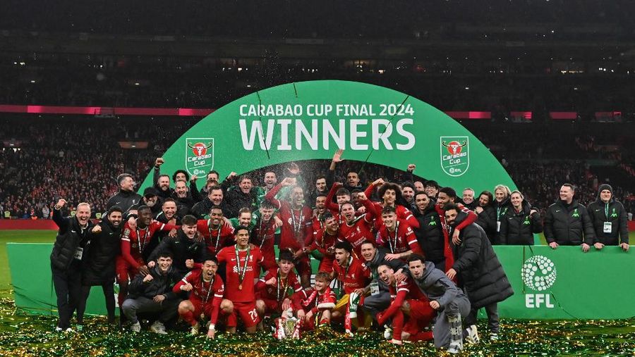 Para pemain Liverpool berpose dengan trofi setelah pertandingan sepak bola final Piala Liga Inggris antara Chelsea dan Liverpool di stadion Wembley, London, pada 25 Februari 2024. Virgil van Dijk mencetak satu-satunya gol di perpanjangan waktu saat Liverpool memenangkan Piala Liga untuk rekor kesepuluh kalinya. (Photo by Glyn KIRK / AFP)