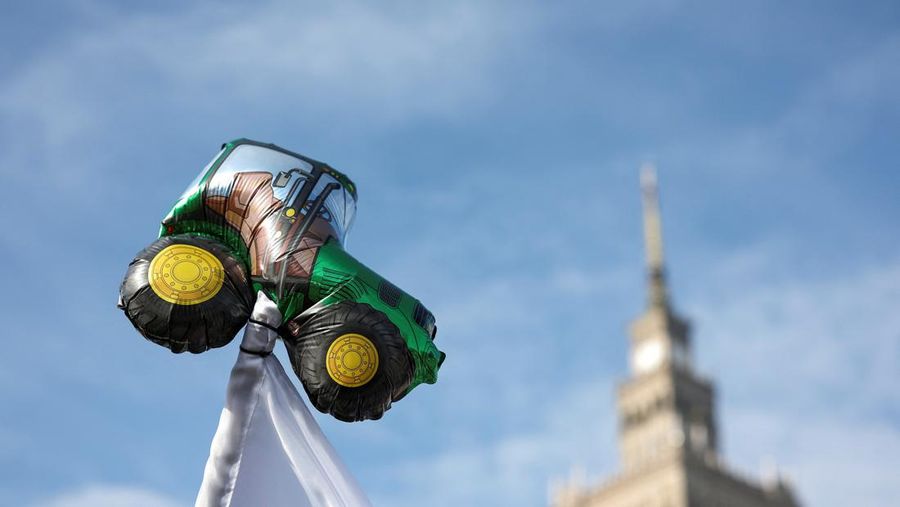 Petani Polandia memegang plakat saat mereka memprotes tekanan harga, pajak dan peraturan ramah lingkungan, keluhan yang disampaikan oleh petani di seluruh Eropa dan terhadap impor produk pertanian dan produk pangan dari Ukraina, dekat Istana Kebudayaan dan Ilmu Pengetahuan di Warsawa, Polandia, Selasa (27/2/2024). (REUTERS/Kacper Pempel)