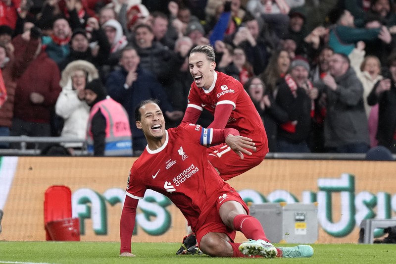 Para pemain Liverpool berpose dengan trofi setelah pertandingan sepak bola final Piala Liga Inggris antara Chelsea dan Liverpool di stadion Wembley, London, pada 25 Februari 2024. Virgil van Dijk mencetak satu-satunya gol di perpanjangan waktu saat Liverpool memenangkan Piala Liga untuk rekor kesepuluh kalinya. (Photo by Glyn KIRK / AFP)