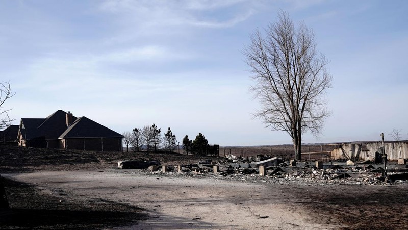Sebuah rumah yang hancur akibat kebakaran hutan Smokehouse Creek terletak di sebelah rumah yang lolos dari kobaran api di Kanada, Texas, AS, 28 Februari 2024. (REUTERS/Nick Oxford)