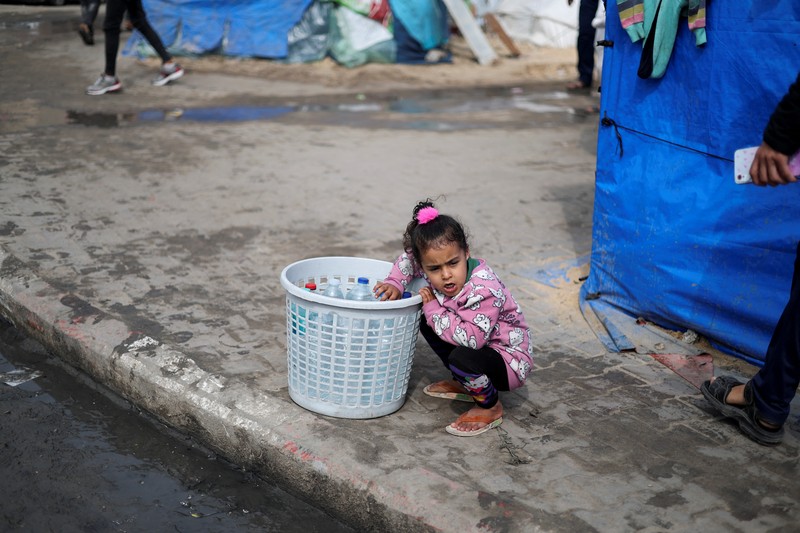 Anak-anak Palestina yang terlantar menunggu untuk menerima makanan gratis di tenda kamp, di tengah kekurangan makanan, saat konflik antara Israel dan Hamas berlanjut, di Rafah di selatan Jalur Gaza, 27 Februari 2024. Anak-anak Palestina yang terlantar menunggu untuk menerima makanan gratis di tenda kamp, di tengah kekurangan makanan, saat konflik antara Israel dan Hamas berlanjut, di Rafah di selatan Jalur Gaza, 27 Februari 2024. (REUTERS/Ibraheem Abu Mustafa)