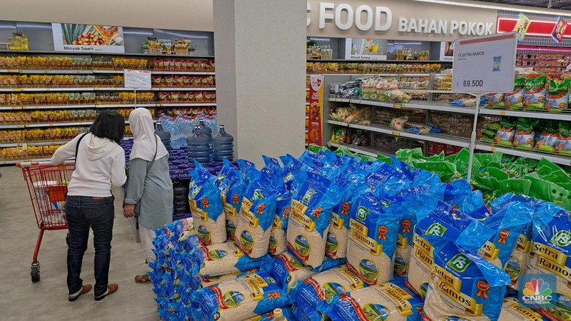 Pengunjung melihat poduk beras kemasan saat berbelanja pada salah satu gerai Lotte Mart di Jakarta, Senin (4/2/2024). (CNBC Indonesia/Faisal Rahman)