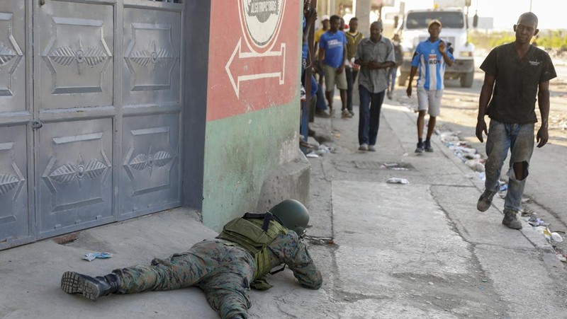 People stand in a courtyard at the international airport in Port-au-Prince, Haiti, Monday, March 4, 2024. Authorities ordered a 72-hour state of emergency starting Sunday night following violence in which armed gang members overran the two biggest prisons and freed thousands of inmates over the weekend. (AP Photo/Odelyn Joseph)