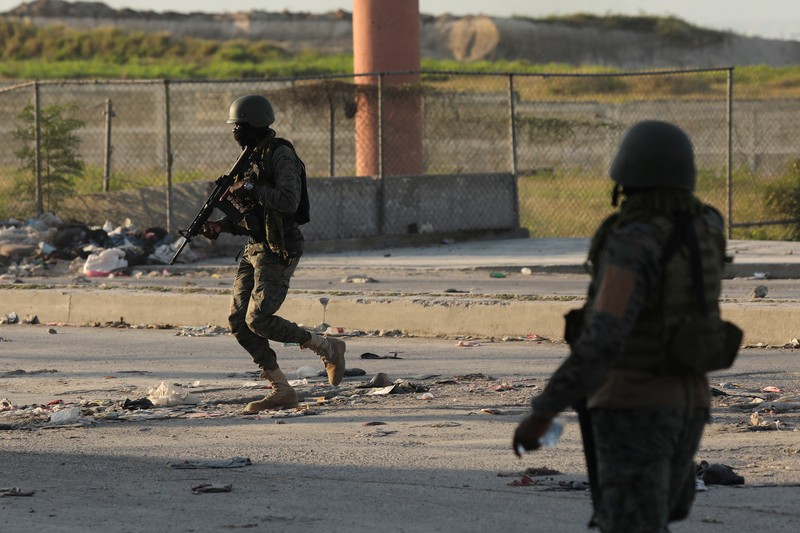 Haiti Violence People stand in a courtyard at the international airport in Port-au-Prince, Haiti, Monday, March 4, 2024. Authorities ordered a 72-hour state of emergency starting Sunday night following violence in which armed gang members overran the two biggest prisons and freed thousands of inmates over the weekend. (AP Photo/Odelyn Joseph)