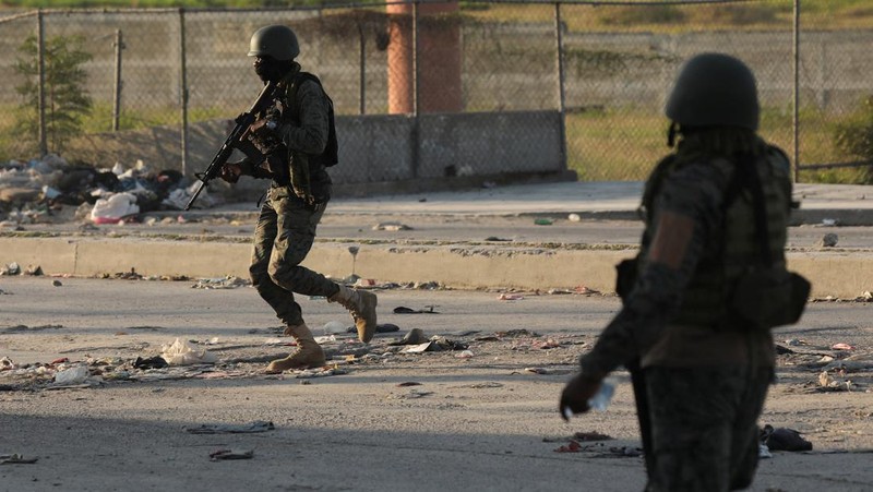People stand in a courtyard at the international airport in Port-au-Prince, Haiti, Monday, March 4, 2024. Authorities ordered a 72-hour state of emergency starting Sunday night following violence in which armed gang members overran the two biggest prisons and freed thousands of inmates over the weekend. (AP Photo/Odelyn Joseph)