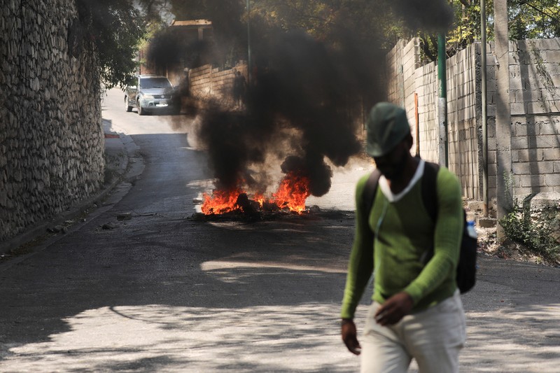 Haiti Violence People stand in a courtyard at the international airport in Port-au-Prince, Haiti, Monday, March 4, 2024. Authorities ordered a 72-hour state of emergency starting Sunday night following violence in which armed gang members overran the two biggest prisons and freed thousands of inmates over the weekend. (AP Photo/Odelyn Joseph)