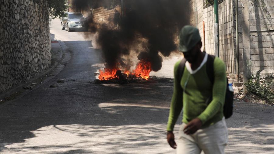 People stand in a courtyard at the international airport in Port-au-Prince, Haiti, Monday, March 4, 2024. Authorities ordered a 72-hour state of emergency starting Sunday night following violence in which armed gang members overran the two biggest prisons and freed thousands of inmates over the weekend. (AP Photo/Odelyn Joseph)