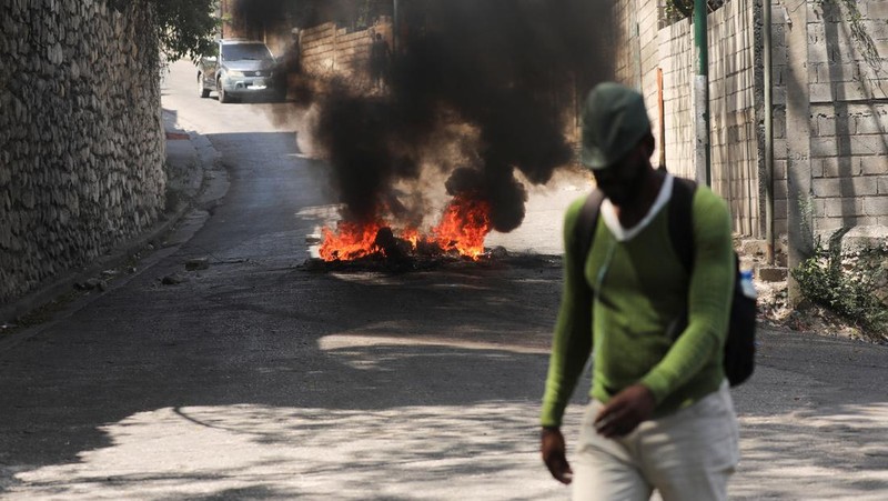 People stand in a courtyard at the international airport in Port-au-Prince, Haiti, Monday, March 4, 2024. Authorities ordered a 72-hour state of emergency starting Sunday night following violence in which armed gang members overran the two biggest prisons and freed thousands of inmates over the weekend. (AP Photo/Odelyn Joseph)