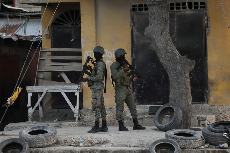 Haiti Violence People stand in a courtyard at the international airport in Port-au-Prince, Haiti, Monday, March 4, 2024. Authorities ordered a 72-hour state of emergency starting Sunday night following violence in which armed gang members overran the two biggest prisons and freed thousands of inmates over the weekend. (AP Photo/Odelyn Joseph)
