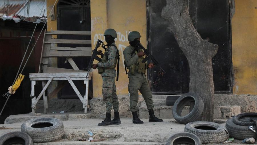 People stand in a courtyard at the international airport in Port-au-Prince, Haiti, Monday, March 4, 2024. Authorities ordered a 72-hour state of emergency starting Sunday night following violence in which armed gang members overran the two biggest prisons and freed thousands of inmates over the weekend. (AP Photo/Odelyn Joseph)