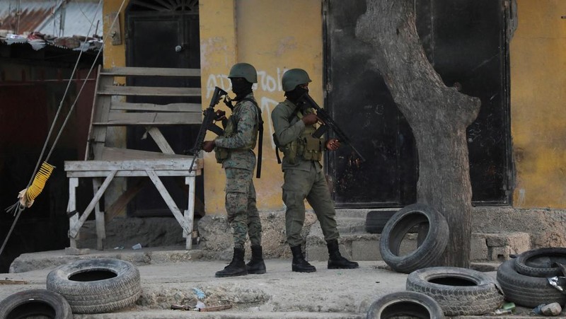 People stand in a courtyard at the international airport in Port-au-Prince, Haiti, Monday, March 4, 2024. Authorities ordered a 72-hour state of emergency starting Sunday night following violence in which armed gang members overran the two biggest prisons and freed thousands of inmates over the weekend. (AP Photo/Odelyn Joseph)