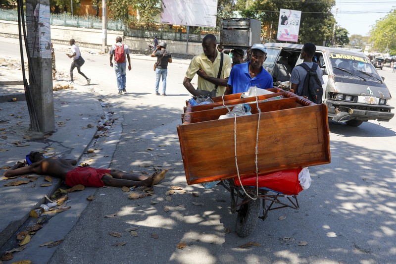 Haiti Violence People stand in a courtyard at the international airport in Port-au-Prince, Haiti, Monday, March 4, 2024. Authorities ordered a 72-hour state of emergency starting Sunday night following violence in which armed gang members overran the two biggest prisons and freed thousands of inmates over the weekend. (AP Photo/Odelyn Joseph)