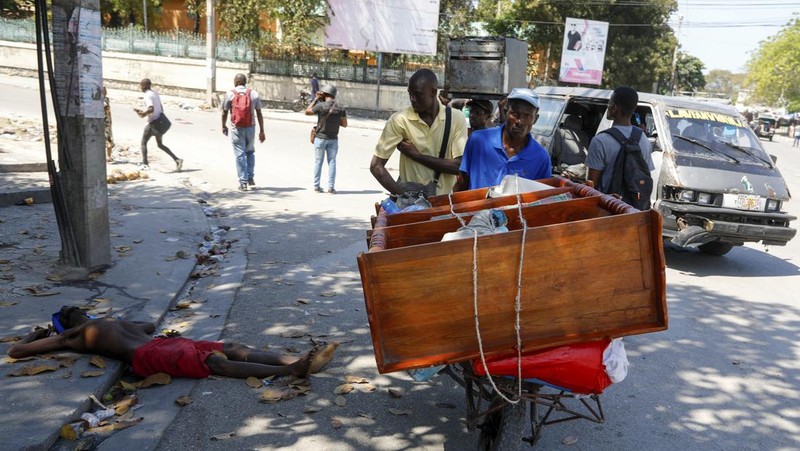 People stand in a courtyard at the international airport in Port-au-Prince, Haiti, Monday, March 4, 2024. Authorities ordered a 72-hour state of emergency starting Sunday night following violence in which armed gang members overran the two biggest prisons and freed thousands of inmates over the weekend. (AP Photo/Odelyn Joseph)