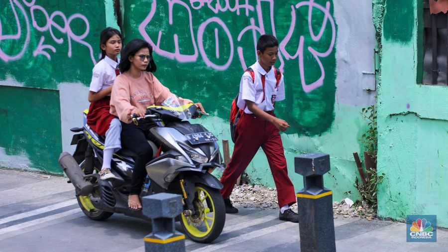 Pengendara sepeda melintasi trotoar jalan di kawasan Matraman, Jakarta, Selasa (5/3/2024). (CNBC Indonesia/Faisal Rahman)