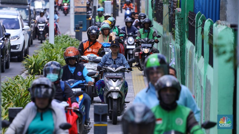 Pengendara sepeda melintasi trotoar jalan di kawasan Matraman, Jakarta, Selasa (5/3/2024). (CNBC Indonesia/Faisal Rahman)